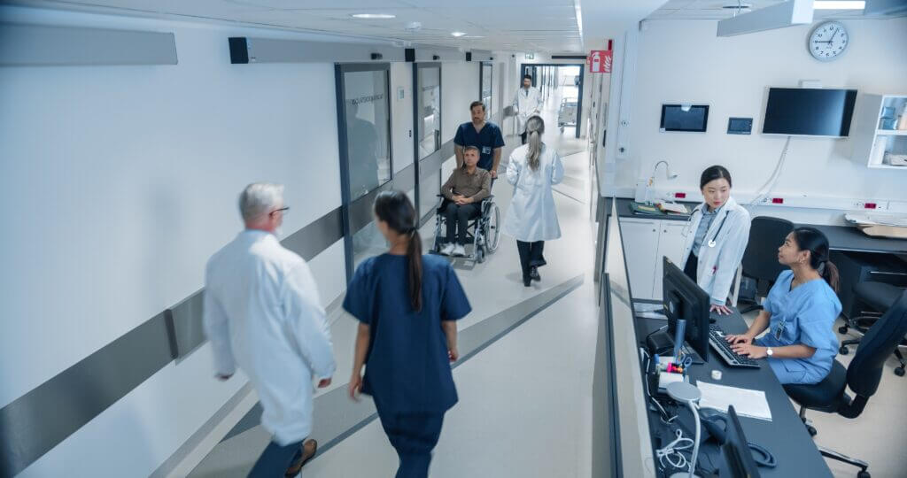 Medical team assisting patients in a busy hospital corridor scene