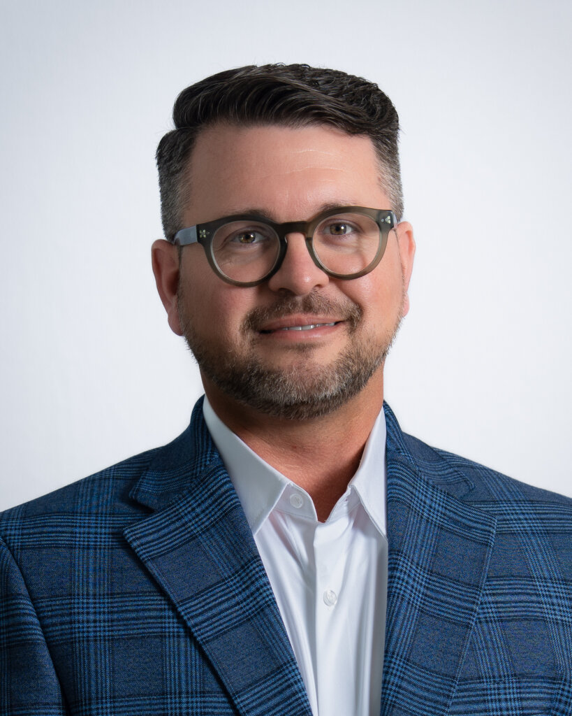 Man in blue plaid suit with glasses and a white shirt