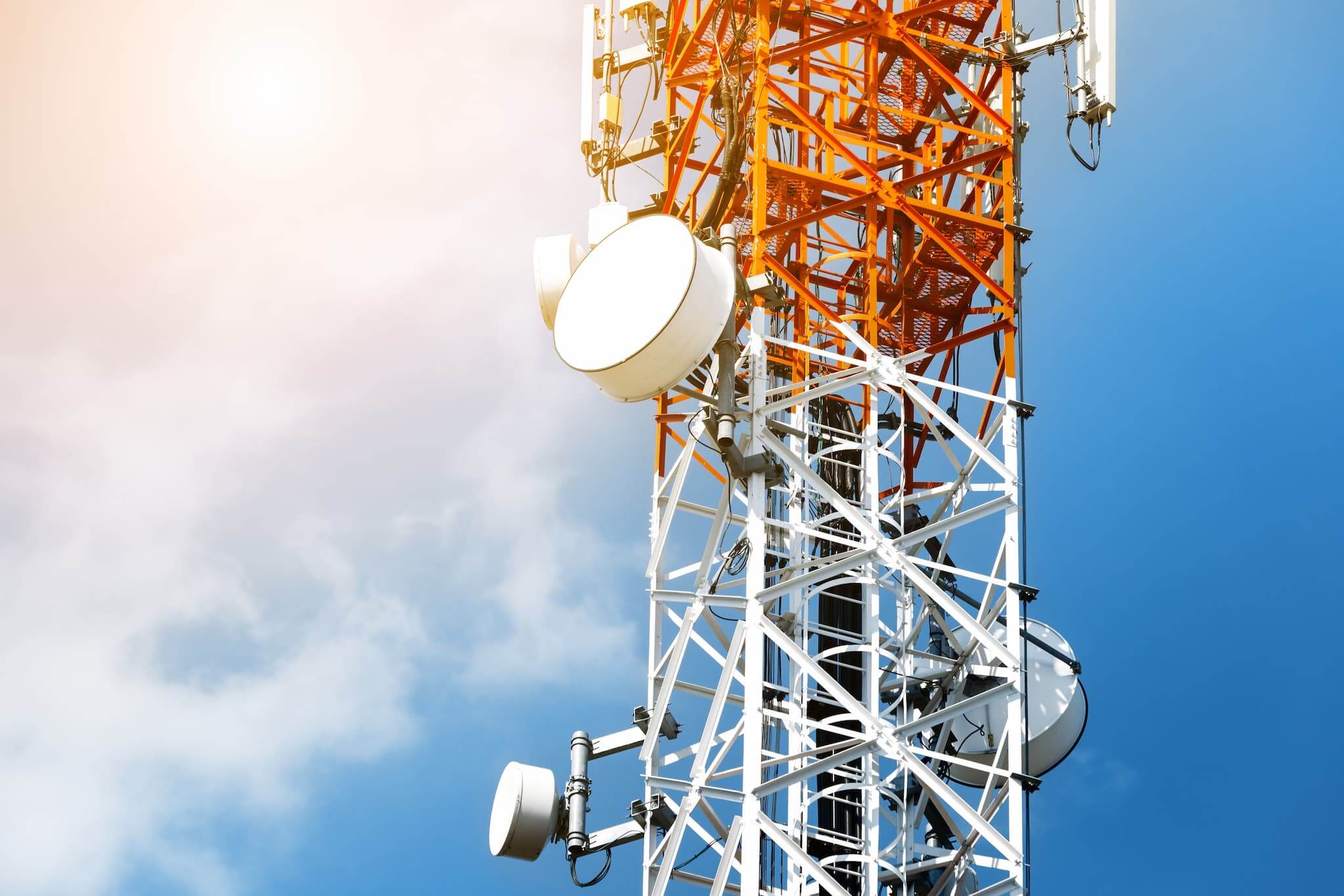 Telecom tower with bright blue sky and technology equipment