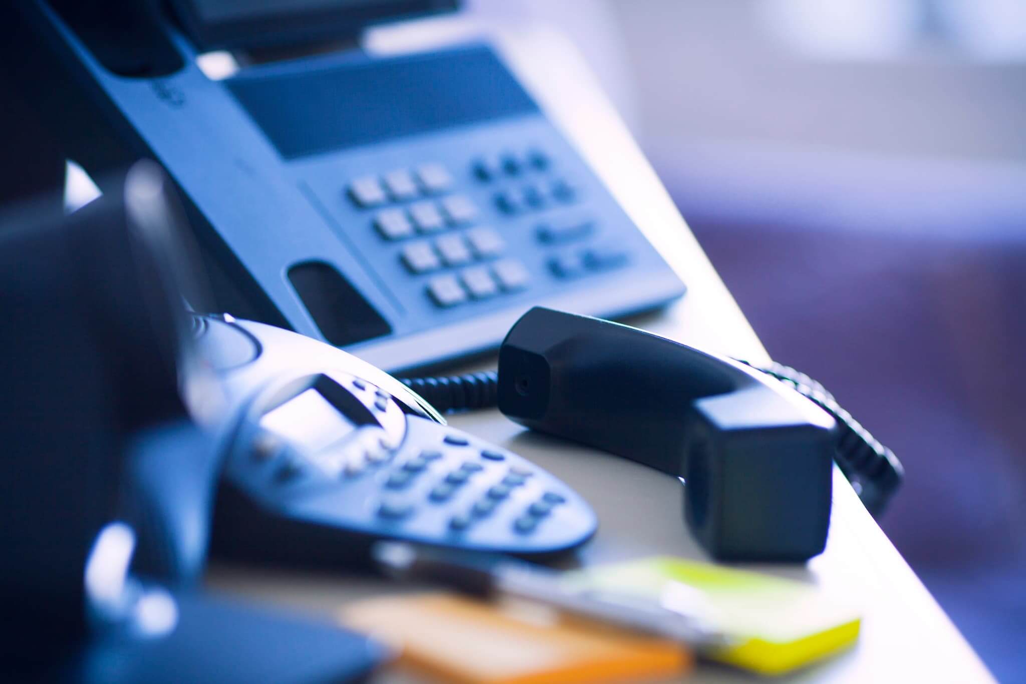 Office desk with telephones and communication devices.