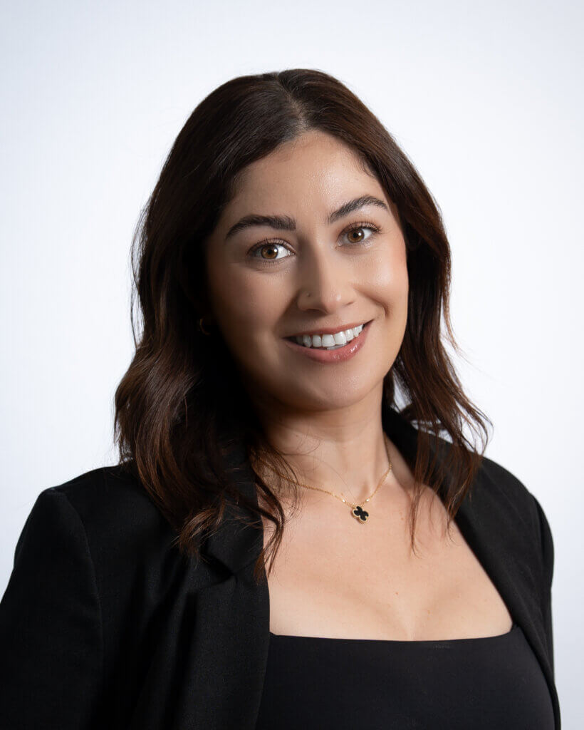 Professional woman smiling in business attire against white background