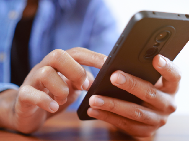 man typing a text on his cell phone