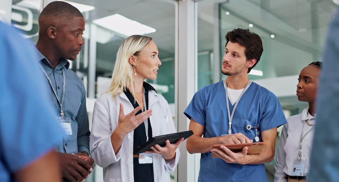 Medical team discussing patient care in hospital corridor.