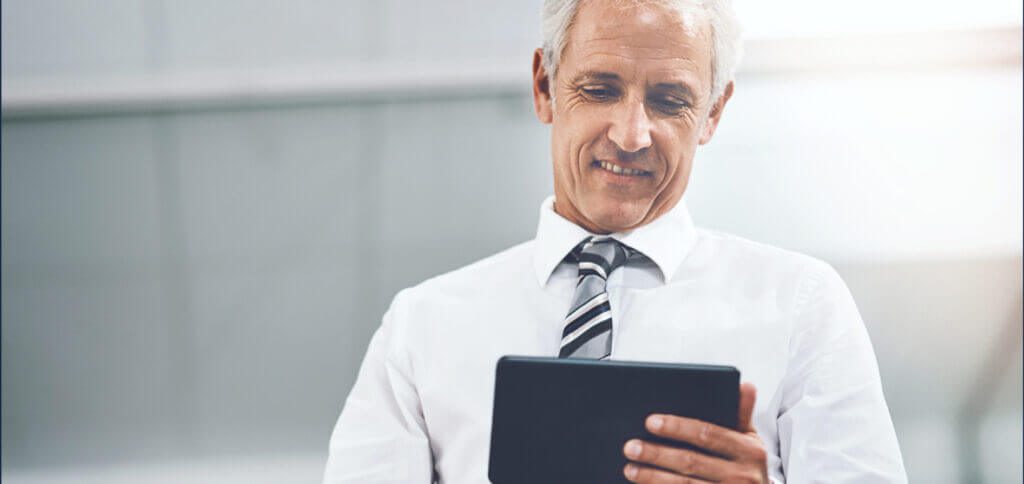 Senior professional using a tablet in a modern office setting