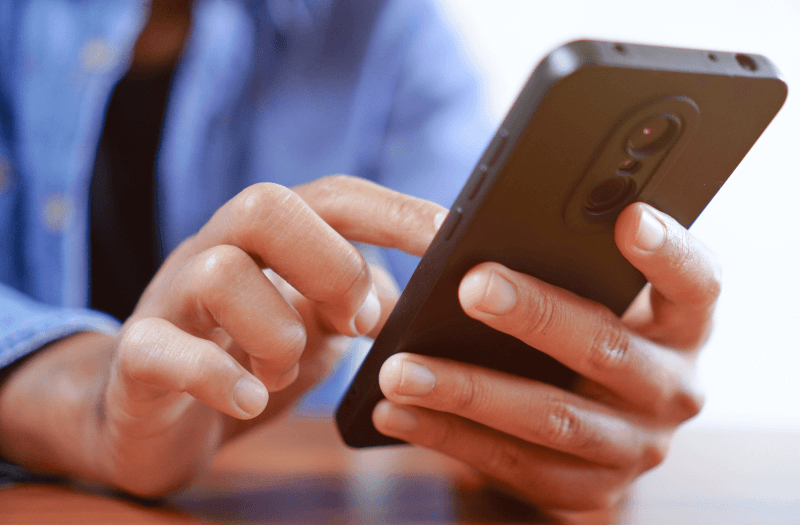 man typing a text on his cell phone